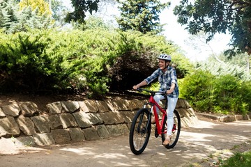 Happy woman cycling in park