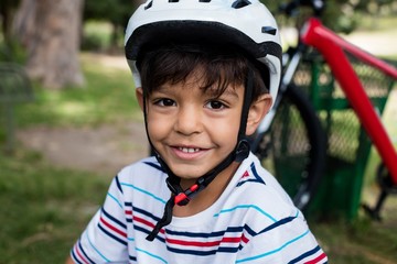 Portrait of smiling boy wearing bicycle helmet in park