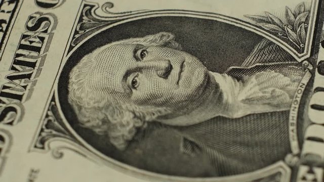 One dollar banknote with a rotating President George Washington's image, macro shot.