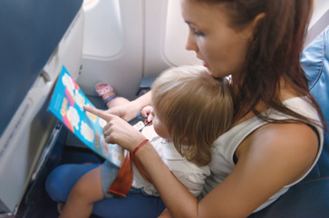 Woman and baby girl in economy class airliner