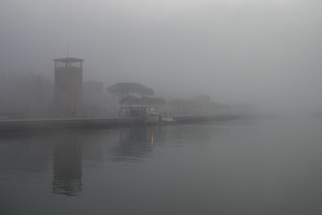 Naklejka premium Small ferry docked in a foggy day