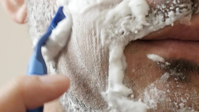 Man using disposable razor for shaving 4K 2160p 30fps UltraHD footage - Male hand shaves beard underside of a chin close-up 3840X2160 UHD video 