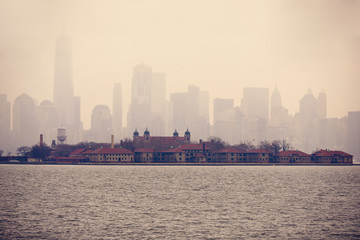 Ellis Island against ghostly New York City Skyline on a cloudy day