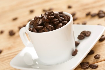 coffee beans in cup on a wooden background