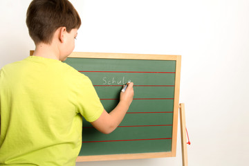 Kind schreibt an der Schultafel