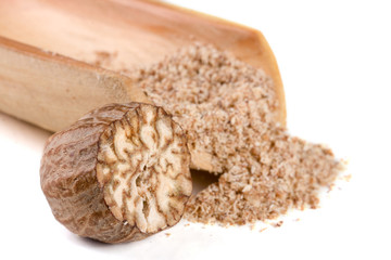 one nutmeg and powder in the scoop isolated on white background