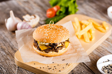 burger with mushrooms and chop on a wooden stand