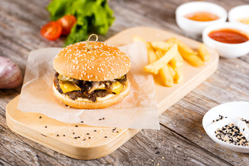 burger with mushrooms and chop on a wooden stand