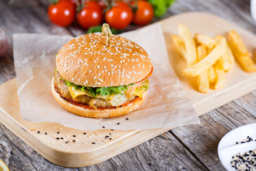 burger with mushrooms and chop on a wooden stand