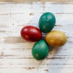Handmade colorful painted easter eggs against rustic wooden background