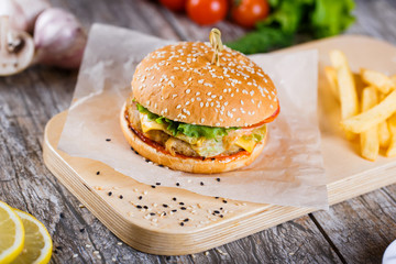 burger with mushrooms and chop on a wooden stand
