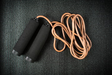 Jimping rope on black yoga mat