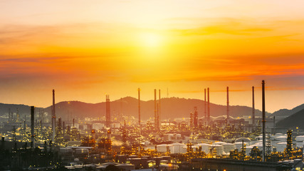 Naklejka premium Aerial view oil refinery night with mountain background during twilight,Industrial zone,Energy power station.
