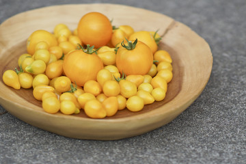 Wood Plate of  Fresh Homegrown Ripe Yellow Tomatoes