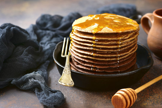 Stack of homemade chocolate ombre pancakes on a rustic backgroun