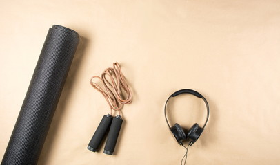 Black yoga mat, headphones and jumping rope