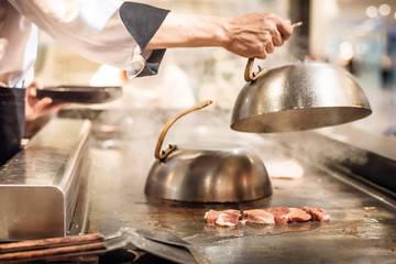 Hand of man take cooking of meat with vegetable grill.