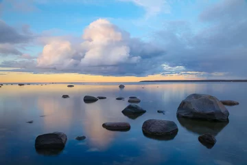 Ruhiger Blick auf den Sonnenuntergang mit Steinen im Wasser. Am Ufer der Ostsee in Estland. © Mykola Iegorov