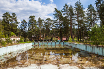 Abandoned overgrown outdoor swimming pool