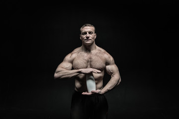 Fototapeta na wymiar sexy athlete man with muscular body holds drink bottle
