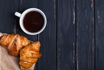 Coffee and croissants on the black table
