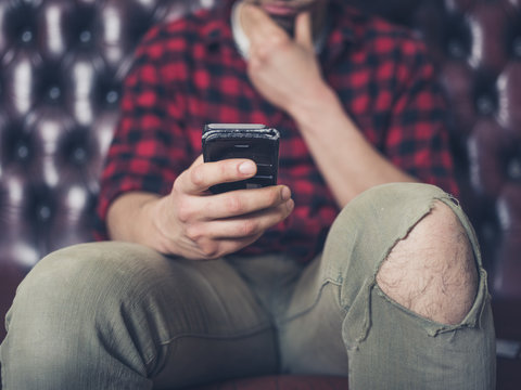 Young man on sofa using smartphone