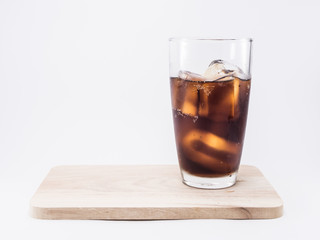 soft drink is cool with ice cubes  two of thirds in glass on wood squares