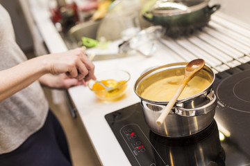Young woman prepares food in a modern kitchen.