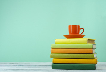Stack of books on wooden tablle with a cup  tea. Education background. Back to school. Copy space for text.