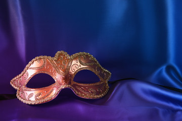 gold venetian mask on blue silk background