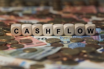 cashflow - cube with letters, money sector terms - sign with wooden cubes - obrazy, fototapety, plakaty
