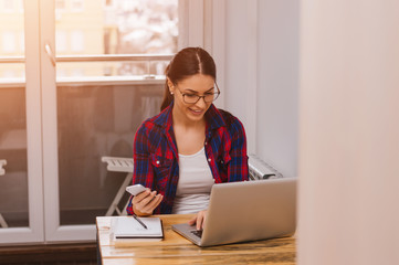 Portrait of young beautiful casual woman holding smartphone