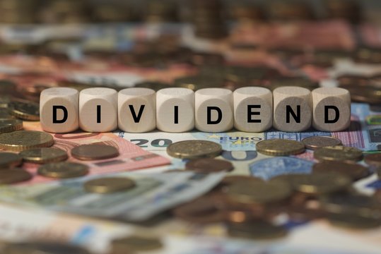 dividend - cube with letters, money sector terms - sign with wooden cubes