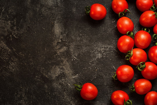 tomatoes frame at the side of dark black cement background