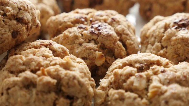 Tasty oatmeal homemade biscuits served on plate slow tilt 4K 2160p 30fps UHD footage - Baked chocolate chip cookies on pile close-up shallow DOF 3840X2160 UltraHD titling video