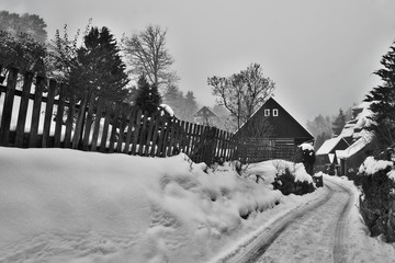 Karba, Machuv kraj, Czech republic - February 04, 2017: wooden cottages and rock on background in snowy winter
