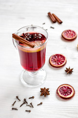 mulled wine with spices in cup on wooden background