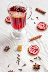 mulled wine with spices in cup on wooden background