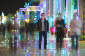 The man stand in the color alley. Evening night time