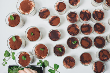 Decorating Italian tiramisu dessert with blueberries and mint