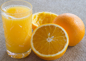 Oranges and glass of juice on  table