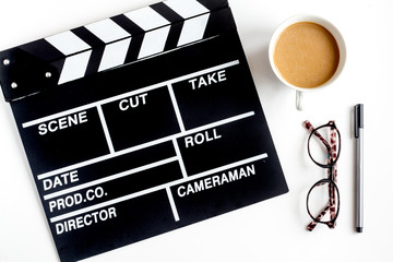 Screenwriter desktop with movie clapper board white background top view
