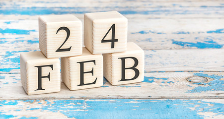 February 24th. Wooden cubes with date of 24 February on old blue