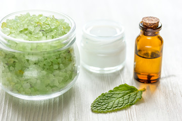 organic cosmetics with herbal extracts of mint on wooden background