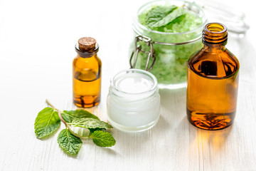 organic cosmetics with herbal extracts of mint on wooden background