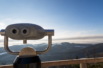 Binoculars looking out winter mountain