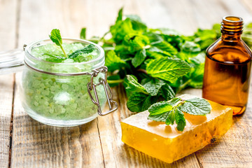 organic cosmetics with herbal extracts of mint on wooden background