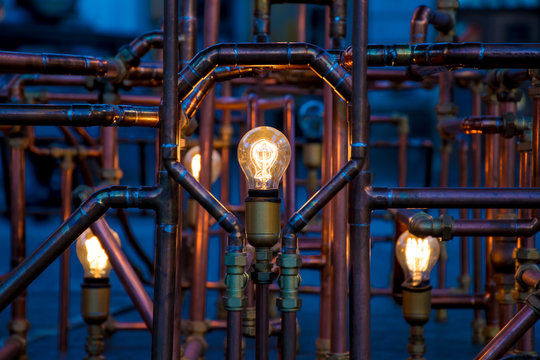 incandescent light bulbs surrounded by pipes