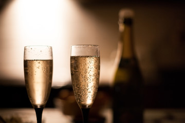 Two elegant champagne glasses on a dark surface