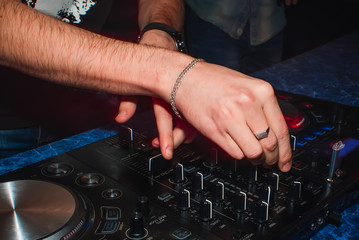 hands of DJ mixer to play the music in nightclub